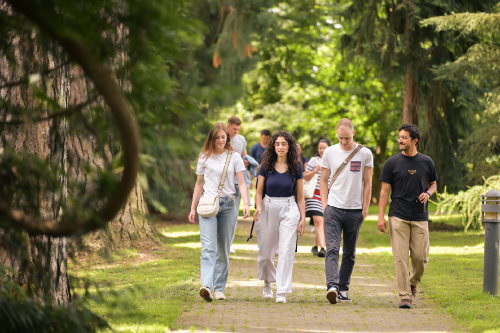 Four students walking through park Hohenheim