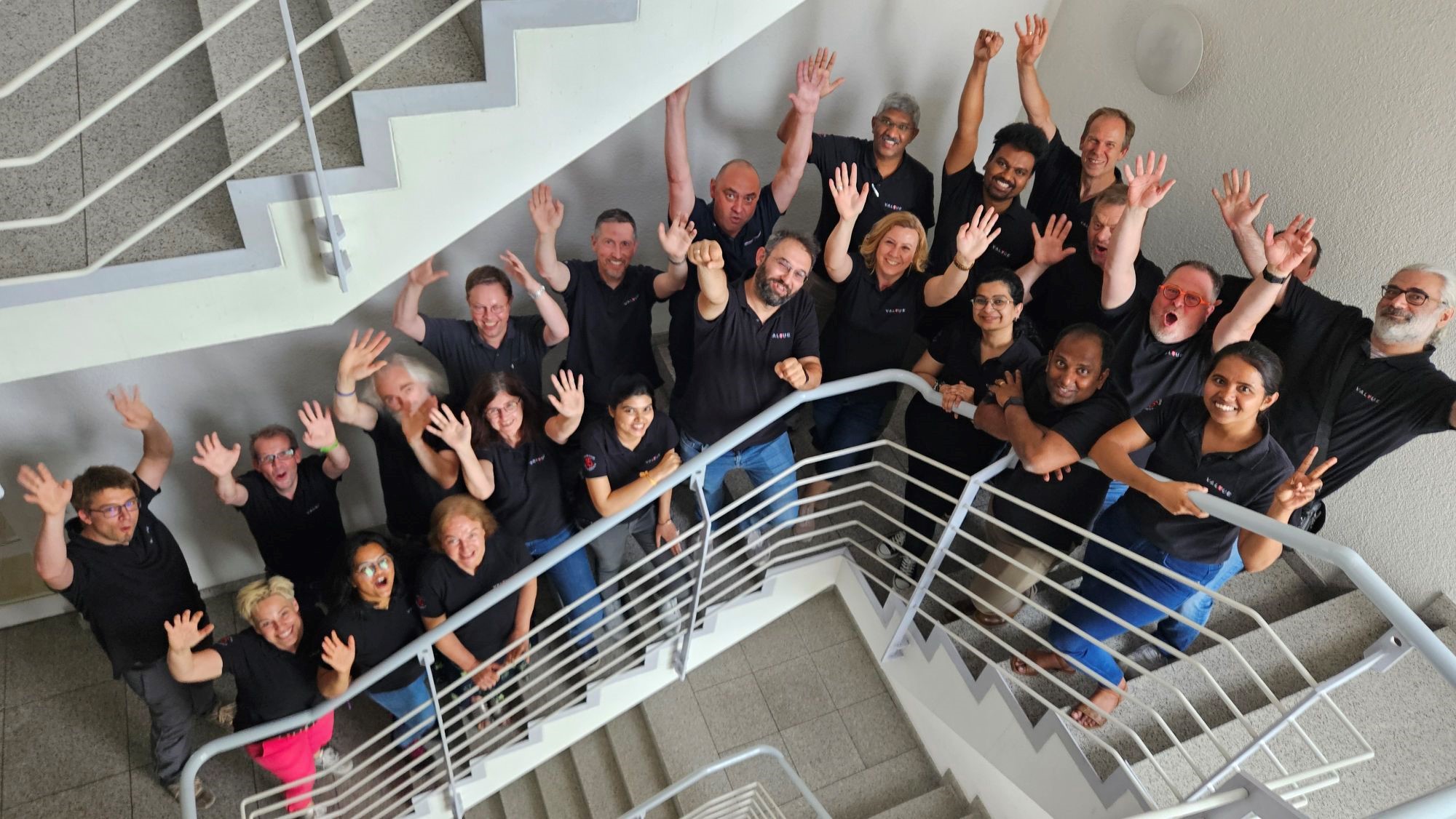 people of valyue team standing in a starecase and waving